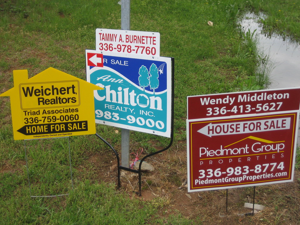 three different home for sale signs from three different realtors